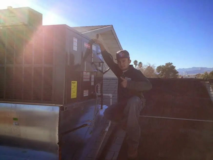 HVAC technician performing Air Duct Cleaning on a rooftop unit in Moon